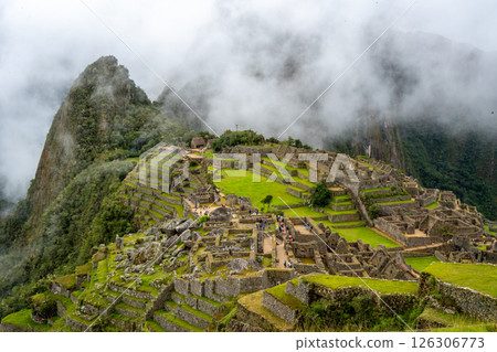 Panoramic view of Machu Picchu ruins surrounded by misty mountains, Peru 126306773