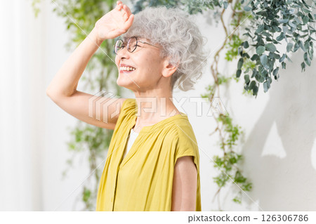 Senior woman wearing a yellow dress Senior woman wearing a yellow dress 126306786