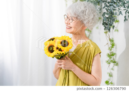 Senior woman holding sunflowers 126306790