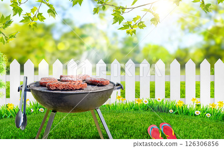 summer time in backyard garden with grill BBQ, wooden table, blurred background 126306856