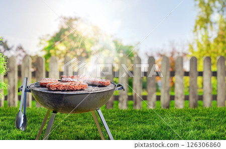 summer time in backyard garden with grill BBQ, wooden table, blurred background 126306860