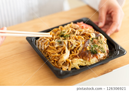 A middle-aged woman eating yakisoba okonomiyaki lunch at her office desk 126306921
