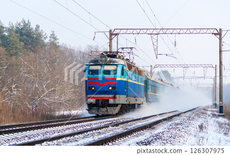 Passenger train rapidly moving along the snow track 126307975
