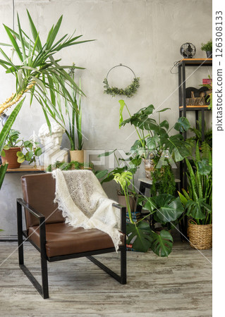 A fragment of the interior with a variety of indoor plants and plaster sculptures. Urban jungle concept. Biophilia design. 126308133