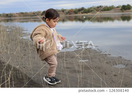 Girl playing on the riverbank 126308140