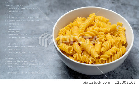A white bowl overflowing with bright yellow twisted pasta on a dark background. A white bowl overflowing with bright yellow twisted pasta on a dark background. 126308165