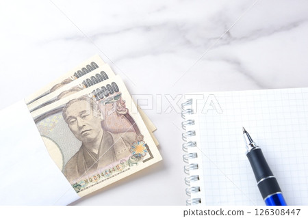 10,000 yen banknote with a portrait of Yukichi Fukuzawa, memo pad, and pen 126308447