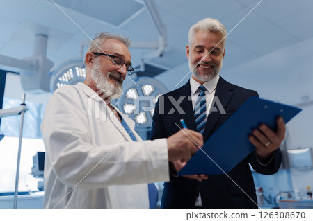 Doctor signing contract with pharmaceutical representative. Doctor signing contract with pharmaceutical representative. 126308670