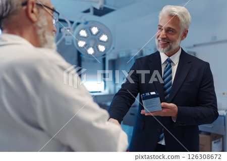 Portrait of pharmaceutical sales representative shaking hand with doctor. Portrait of pharmaceutical sales representative shaking hand with doctor. 126308672
