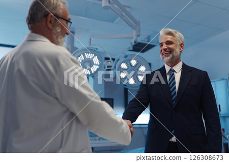 Portrait of pharmaceutical sales representative shaking hand with doctor. 126308673