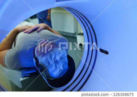 Male patient undergoing CT scan examination in hospital. 126308675