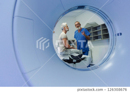 Doctor explaining CT scan results to patient in hospital setting Doctor explaining CT scan results to patient in hospital setting 126308676