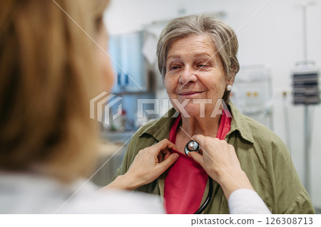 Geriatrician listening to senior patient's heartbeat. Geriatrician listening to senior patient's heartbeat. 126308713