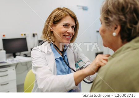 Geriatrician listening to senior patient's heartbeat. 126308715