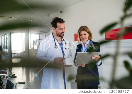 Confident female medical sales representative introducing pharmaceutical products to doctor. 126308727
