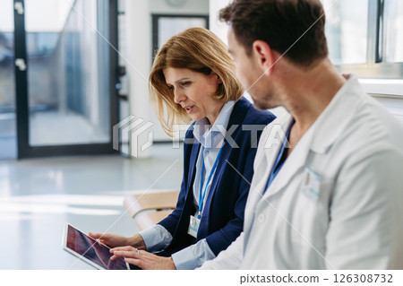 Pharmaceutical rep and doctor discussing drug samples and prescriptions 126308732