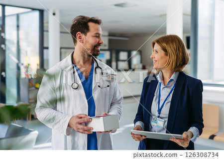 Female medical sales representative presenting medication to doctor 126308734