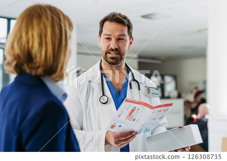 Female medical sales representative presenting medication to doctor 126308735