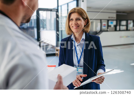 Female medical sales representative presenting medication to doctor 126308740
