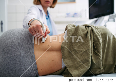Medical examination with ultrasound probe on lower back 126308776