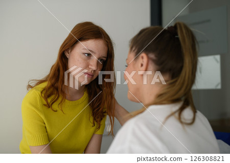 Doctor offering reassurance to frightened teen patient. 126308821