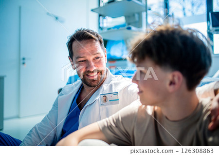 Compassionate doctor supporting anxious teenage patient before surgery. 126308863