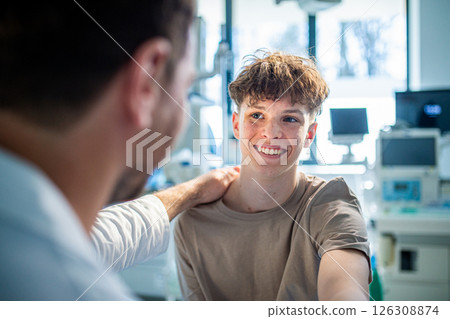 Compassionate doctor supporting anxious teenage patient before surgery. 126308874