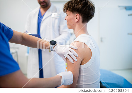 Vaccination of teenage boy during routine health checkup at hospital 126308894