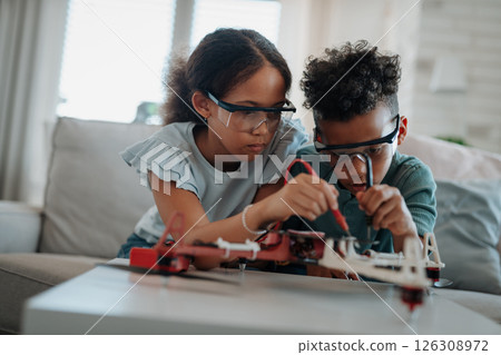 Kids building their first homemade robot at home. 126308972