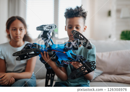 Kids playing with drone at home. 126308976
