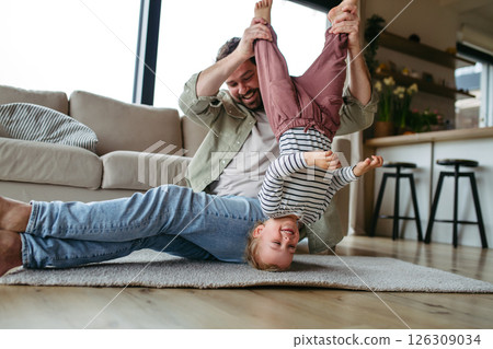 Playful father holding little son upside down. 126309034