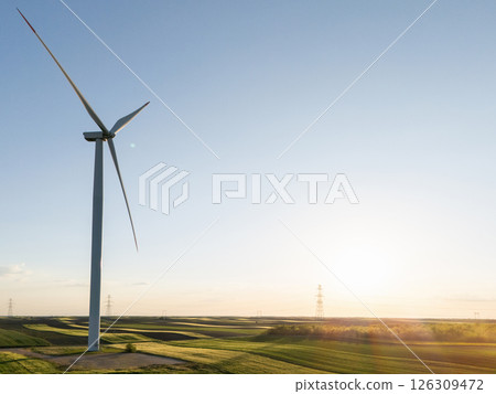 Wind turbine on an agricultural filed at sunset 126309472