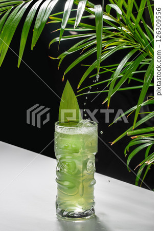 Refreshing green tropical cocktail with ice and palm leaf garnish. Mojito drink recipes, alcoholic cocktail, 126309556