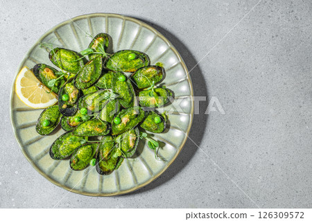 Green mussels with herb sauce and lemon garnish on a ceramic plate. top view. copy space 126309572