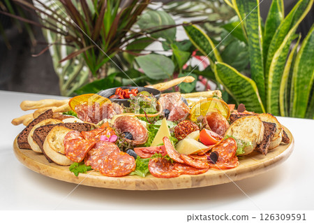 Rustic charcuterie platter with assorted meats, cheeses, and artisan bread. 126309591