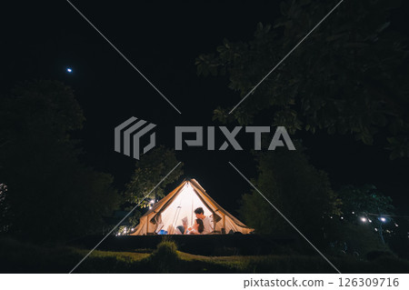 asian couple relax in camping tent on summer vacation asian couple relax in camping tent on summer vacation 126309716