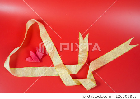 minimal flat lay valentine's day decoration item with paper heart on red background 126309813
