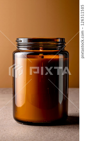 A brown glass jar with a candle inside of it 126311585
