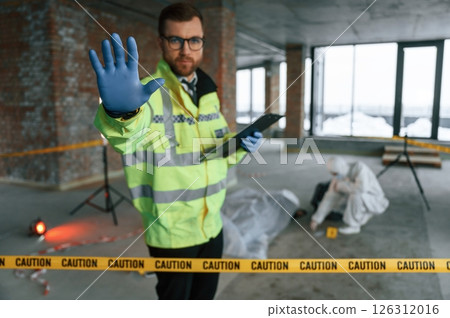 Stop gesture by a hand, no trespassing. Detectives are collecting evidence in a crime scene near dead body Stop gesture by a hand, no trespassing. Detectives are collecting evidence in a crime scene near dead body 126312016