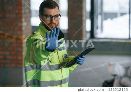 Stop gesture by a hand, no trespassing. Detectives are collecting evidence in a crime scene near dead body 126312133