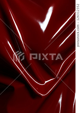 Shiny red vinyl material wrinkled and reflective background texture Shiny red vinyl material wrinkled and reflective background texture 126312352