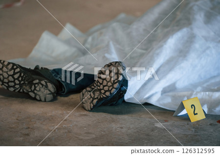 Dead body of a man is on the ground, covered in white cloth. Conception of murder, homicide Dead body of a man is on the ground, covered in white cloth. Conception of murder, homicide 126312595