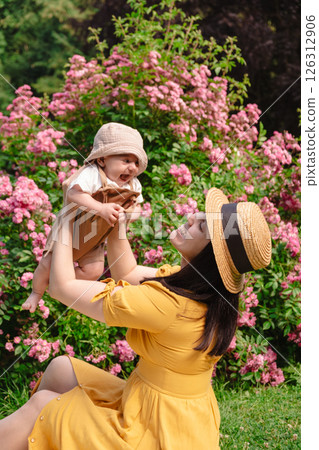 Joyful Mother and Baby in Blooming Garden Joyful Mother and Baby in Blooming Garden 126312906