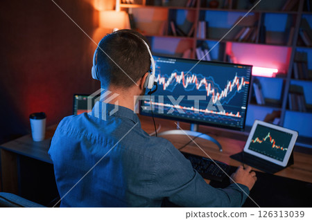 Stock trader is working by pc indoors. Conception of exchange and money Stock trader is working by pc indoors. Conception of exchange and money 126313039
