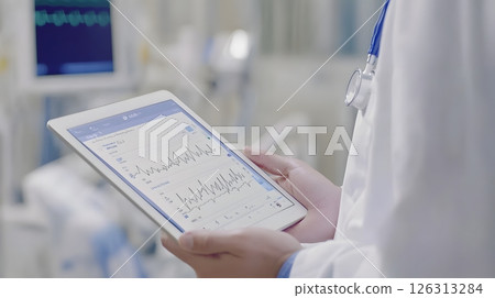 Tablet interface showing heart rhythm and patient stats held by professional doctor, tech-driven hospital environment, 126313284
