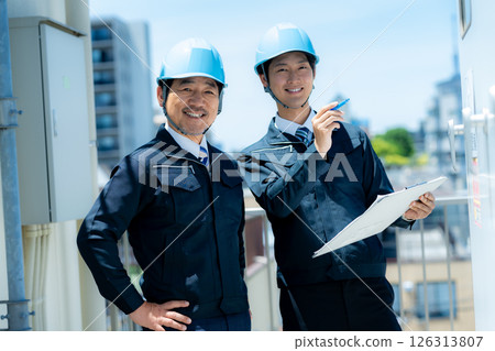 Businessmen in work clothes having a meeting at the site Businessmen in work clothes having a meeting at the site 126313807