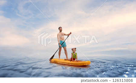 Happy, smiling man, father paddleboarding, daughter stretching on on sup board in calm ocean under blue sky. Composite image. Happy, smiling man, father paddleboarding, daughter stretching on on sup board in calm ocean under blue sky. Composite image. 126313808