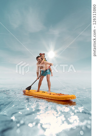 Happy smiling father standing on paddle board with his little happy child, daughter sitting on his back against sunny sea background 126313860