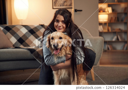 Portrait of woman that is with golden retriever dog at home 126314024