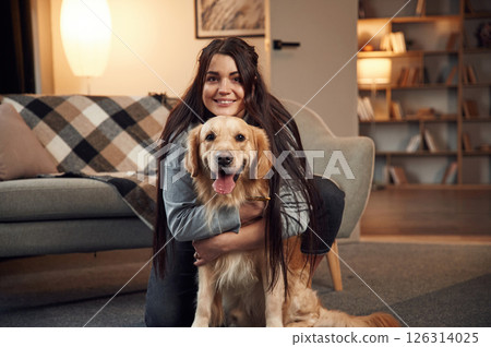 Portrait of woman that is with golden retriever dog at home 126314025